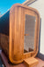 Wooden sauna cabin with glass door on a wooden platform