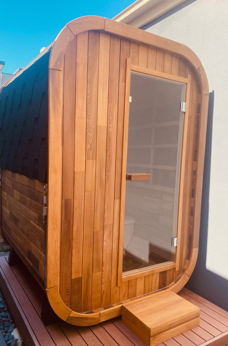 Wooden sauna cabin with glass door on a wooden platform
