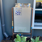 Two stage water filter system with cover installed at home