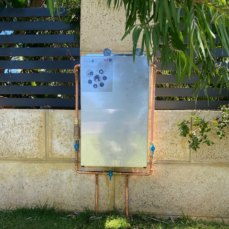 Premium two stage whole house water filter attached to a concrete wall outdoors