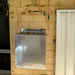 AquaCo whole house water filter system mounted on brick wall with copper piping and pressure gauges