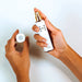 HYDROGEN HEALTH hydrogen skin mister with white and gold design held in hands with cap removed
