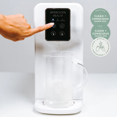 Hydrogen Health hydrogen water device dispensing water into a clear glass pitcher with touch control panel
