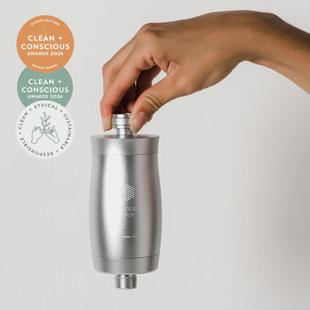 HYDROGEN HEALTH silver shower filter held by hand with Clean + Conscious Awards 2024 badges