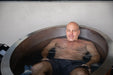 Man relaxing in a Stryke Recovery ice bath with eyes closed for muscle recovery and relaxation