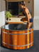 Stryke Recovery wooden ice bath with stainless steel bands and woman preparing to enter