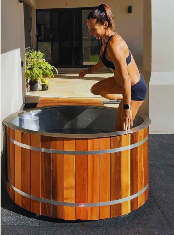 Stryke Recovery wooden ice bath with stainless steel bands and woman preparing to enter