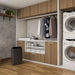 Ionmax black dehumidifier placed in modern laundry room with wooden cabinets and stacked washer dryer