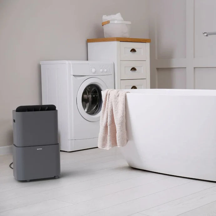 Ionmax gray dehumidifier placed on white floor in bathroom near bathtub and washing machine