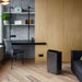Ionmax black dehumidifier placed on wooden floor in modern living room with gray walls and furniture