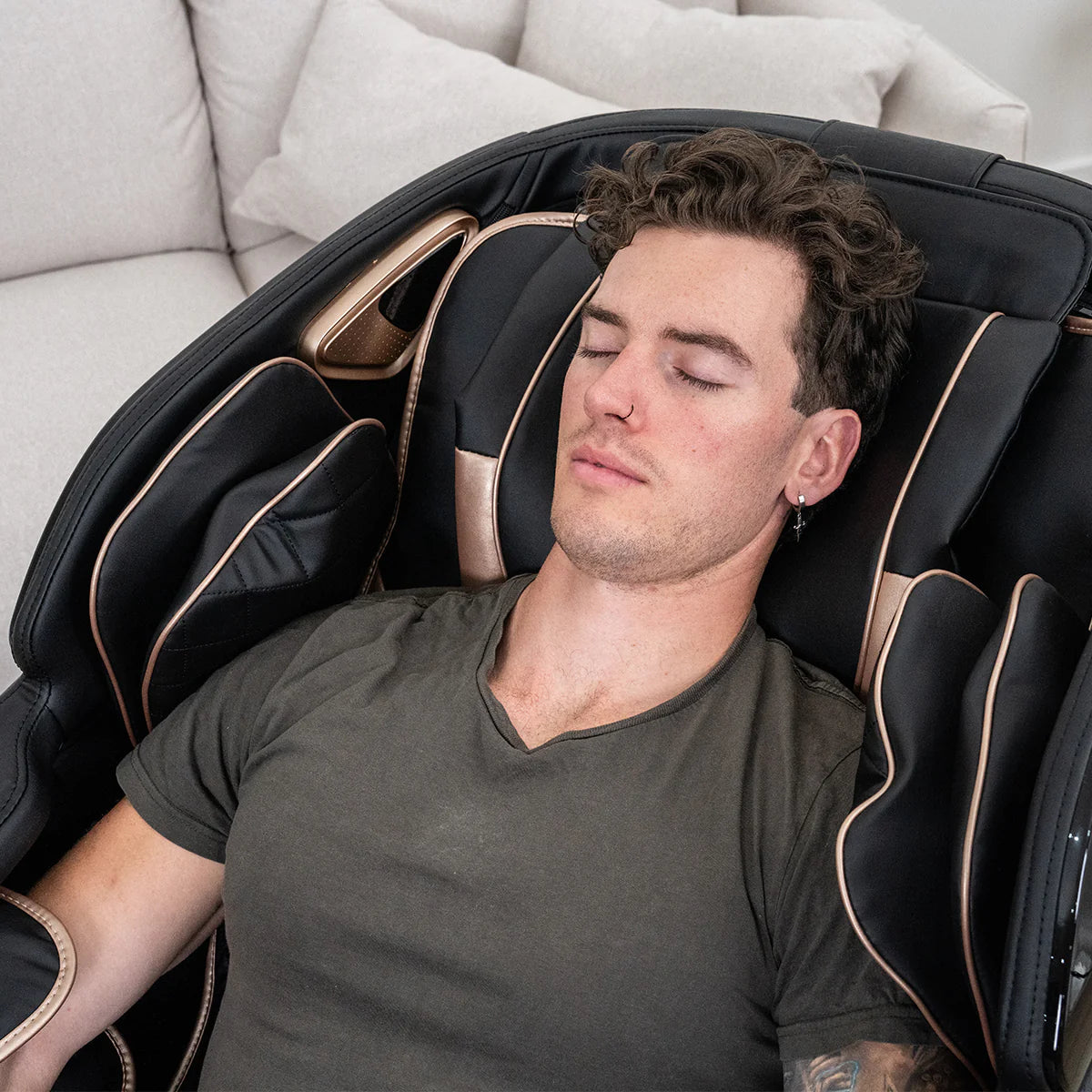 Man relaxing in Lifespan Fitness black massage chair with cushioned arm and neck support