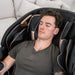 Man relaxing in Lifespan Fitness black massage chair with cushioned arm and neck support