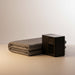 Oak Sleep smart cooled mattress pad with compact black control unit folded neatly on a beige surface