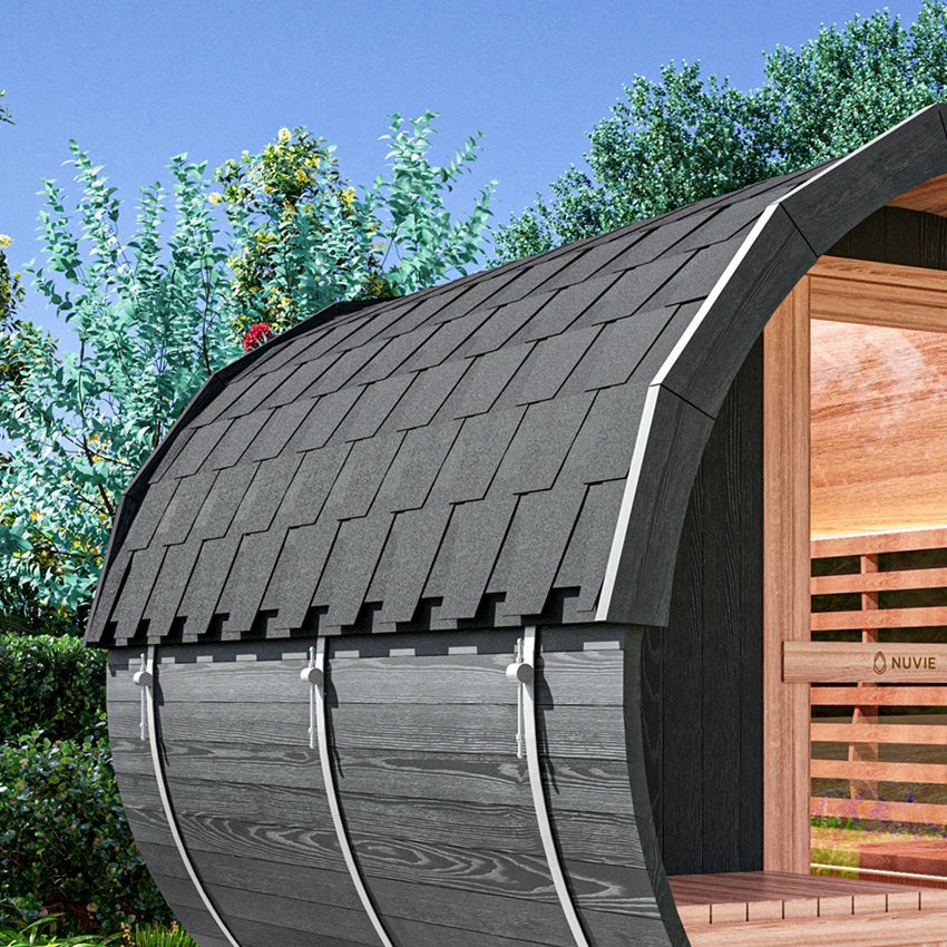 Nuvie outdoor barrel sauna with curved black wood exterior and shingle roof in a garden setting
