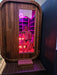 Stryke Recovery outdoor infrared sauna with wooden exterior and red light therapy interior
