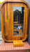Stryke Recovery outdoor infrared sauna made of wood with glass door, towels, and seating inside