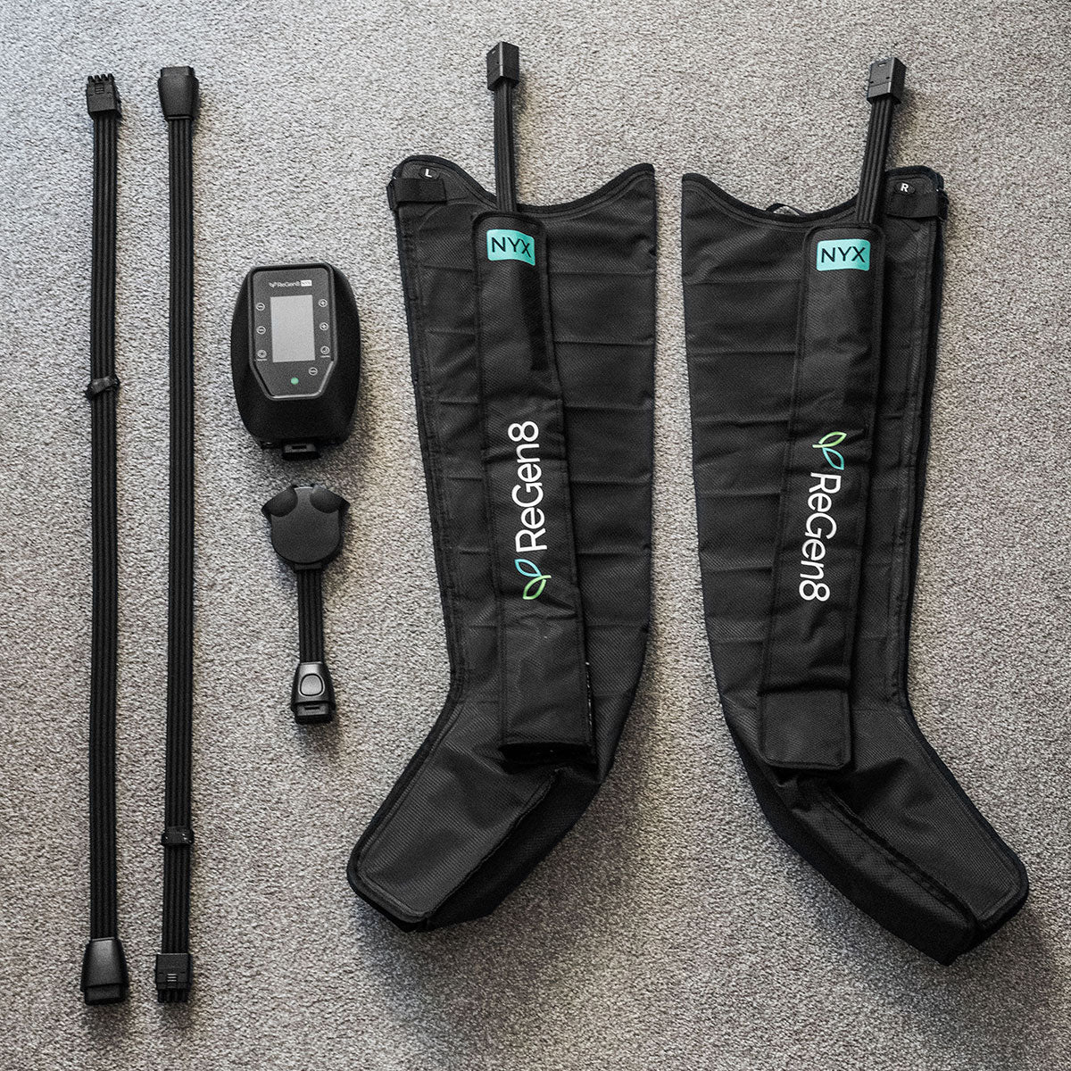Lifespan Fitness black ReGen8 compression boots with controller and accessories on gray surface
