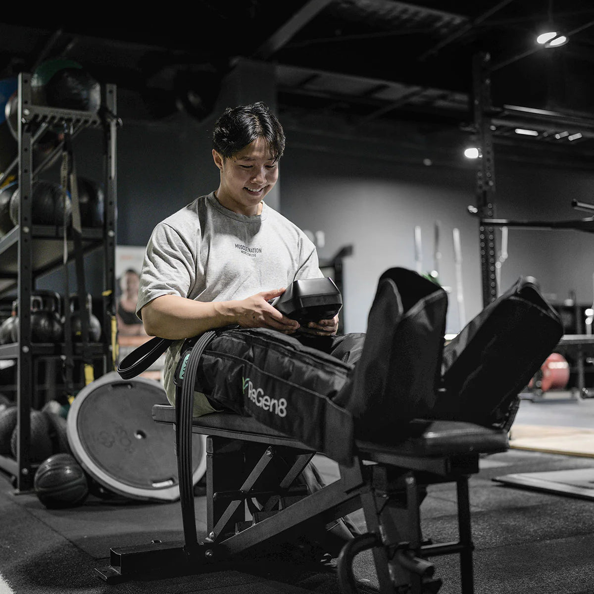 Man using Lifespan Fitness compression boots on legs while seated in gym setting