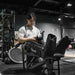Man using Lifespan Fitness compression boots on legs while seated in gym setting
