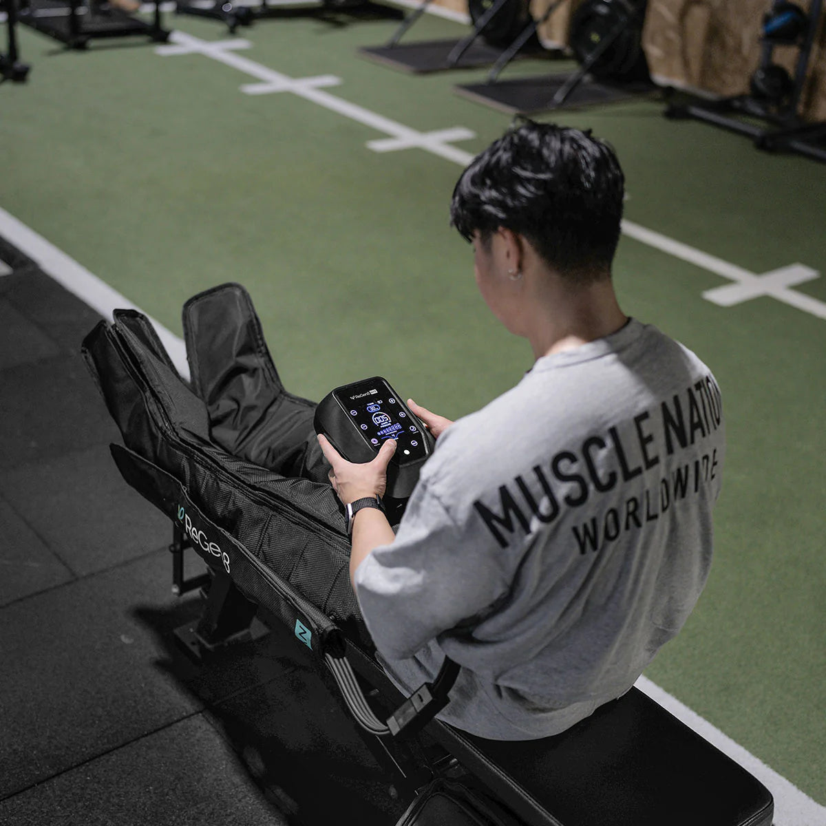 Person using Lifespan Fitness compression boots with digital control panel on a gym bench