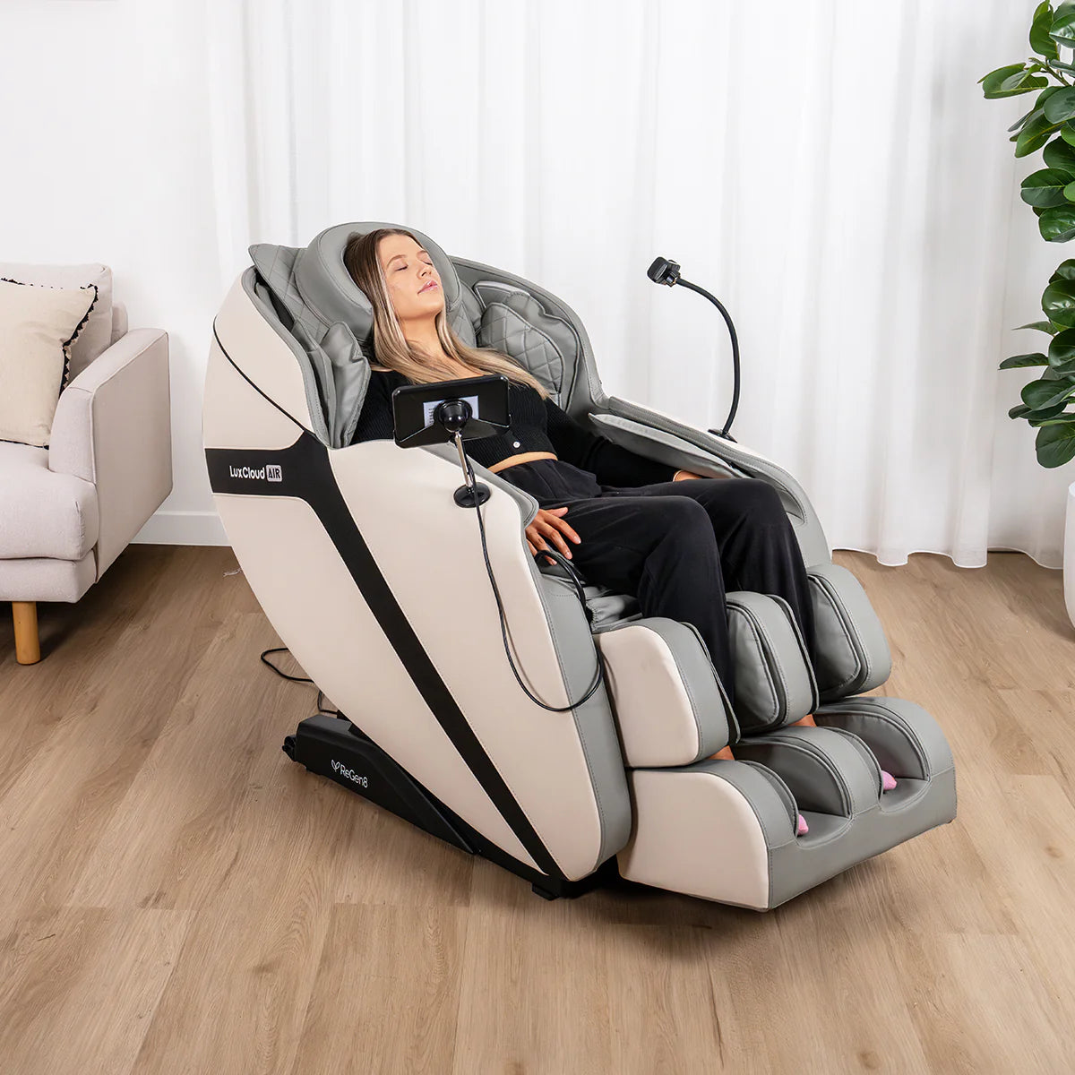 Lifespan Fitness massage chair in beige and gray with woman relaxing in modern living room setting