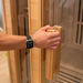 Person opening Lifespan Fitness wooden sauna door with glass panel and wooden handle