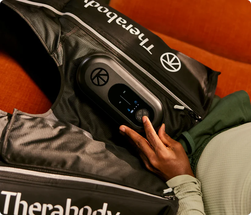 Therabody compression boots with control panel being adjusted on a persons leg for recovery therapy