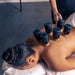 Therabody hot and cold therapy cupping device set applied on womans back during treatment session