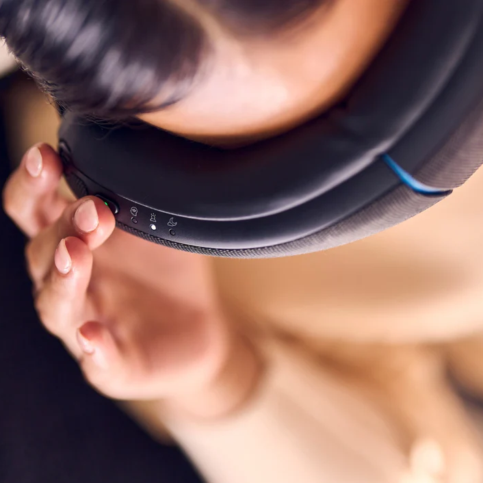 Therabody eye and temple massager worn on head with control buttons visible for relaxation