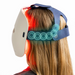 Therabody LED mask worn on head showing red light therapy with adjustable navy blue straps