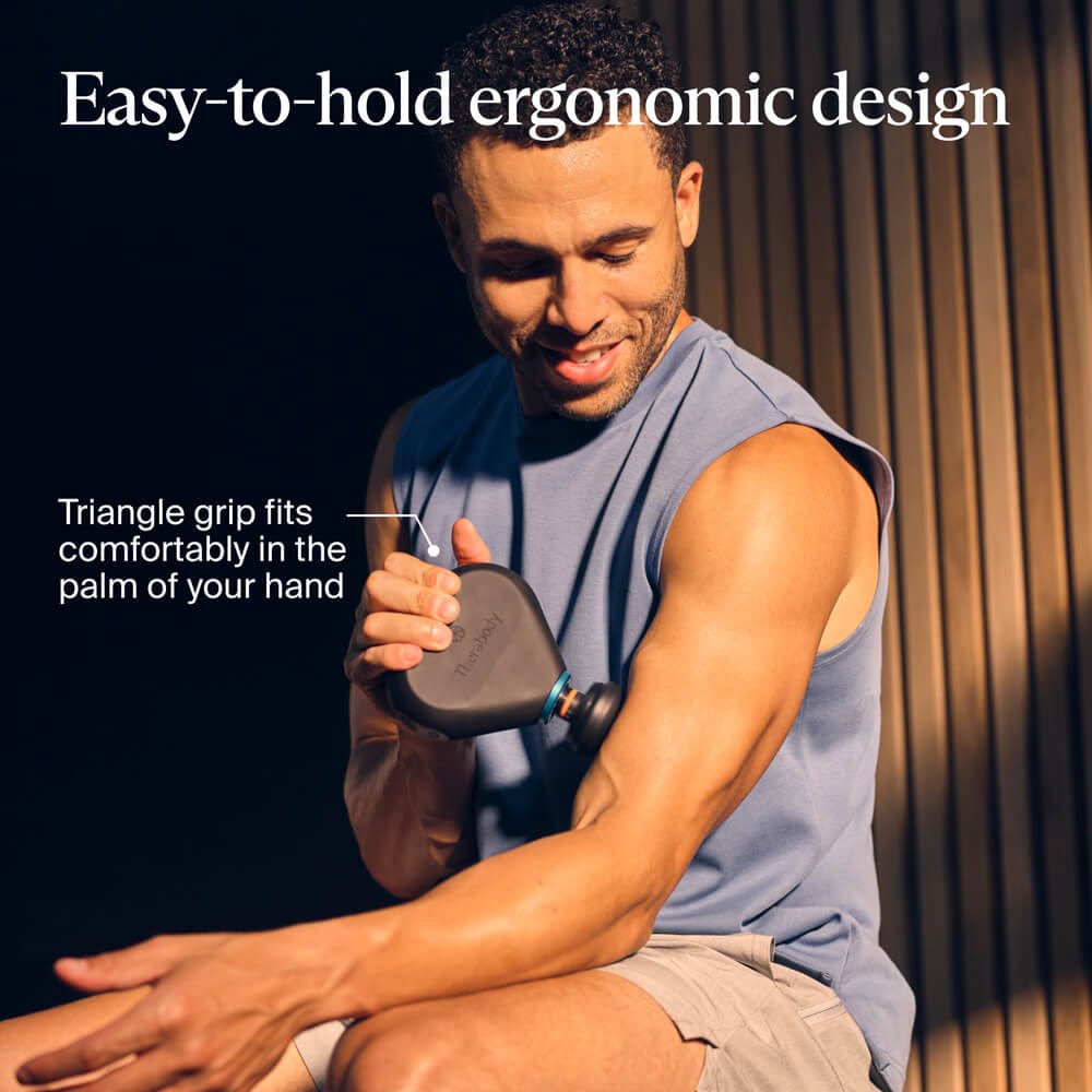 Therabody massage gun with easy-to-hold ergonomic triangle grip used on arm muscle