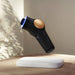 Therabody theraface pro black and gold skincare device floating above a white platform