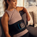 woman wearing therabody recoverytherm back on a couch