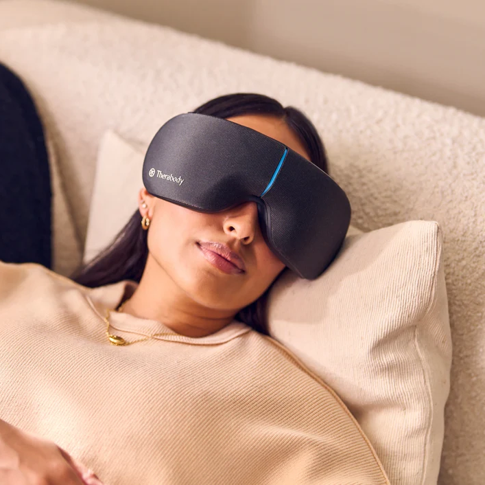 Woman laying down wearing therabody smartgoggles eye massager