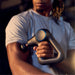 Therabody massage gun being used on arm muscles for deep tissue muscle relief