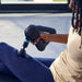 Therabody massage gun being used on leg for muscle relaxation and recovery