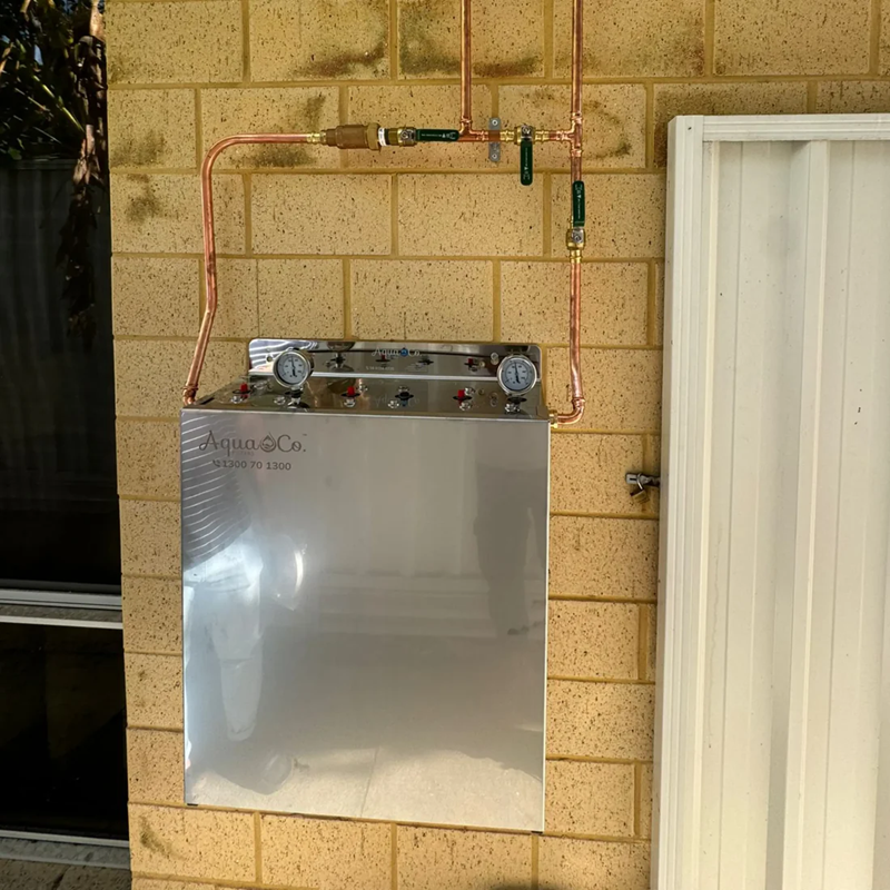 Premium whole house water filtration system mounted to brick wall