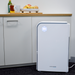Welcare white air purifier placed on floor next to kitchen cabinets with digital display light