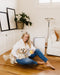 Welcare air purifier in modern living room with woman sitting on floor holding a dog